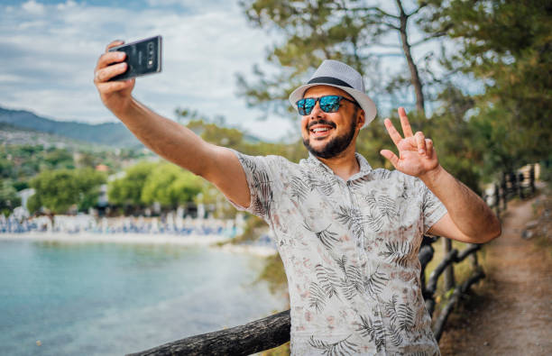 istock Smiling man taking selfies on the seaside 1576477158
