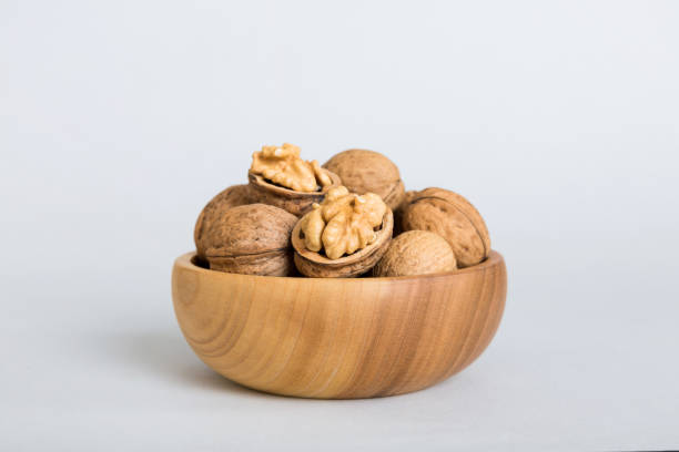 istock Fresh healthy walnuts in bowl on colored table background. Top view Healthy eating bertholletia concept. Super foods 1576479531