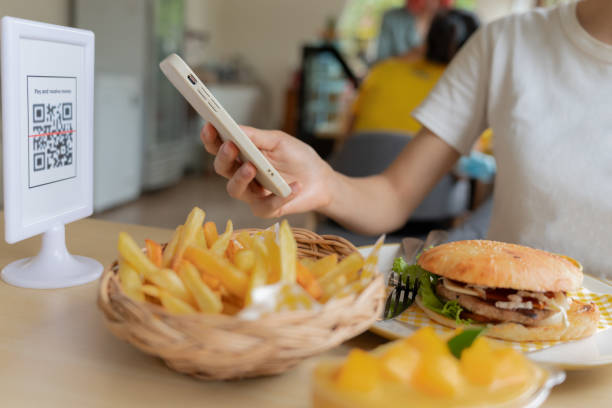 istock Woman use smartphone to scan QR code for order menu in cafe restaurant with a digital delivery. Choose menu and order accumulate discount. E wallet, technology, pay online, credit card, bank app. 1576488309