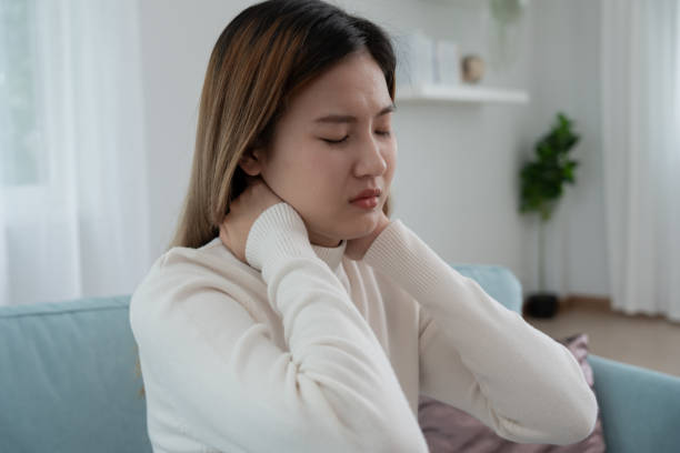 síndromes de consultório, mulher massageando dor no pescoço devido ao trabalho e usando um computador, composto digital de uma coluna focada de dor no pescoço e sintomas de dor no ombro , lesões, cuidados de saúde, médico, miosite - physical injury backache occupation working - fotografias e filmes do acervo