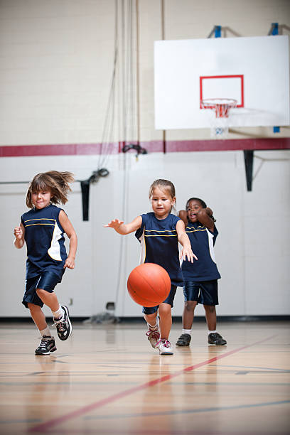 Three young basketball players on the court.