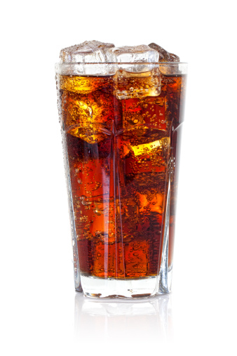 Cola with ice and popcorn over red background, with copy space