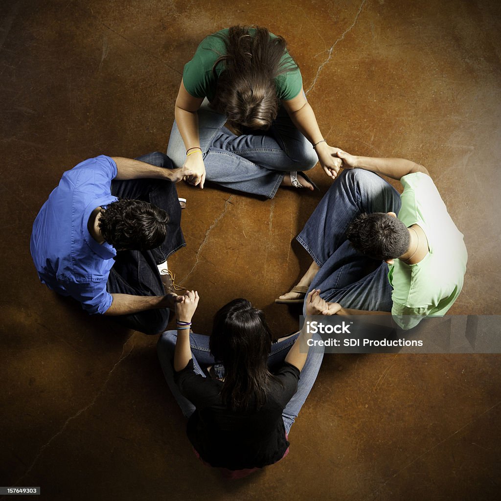 Group of Young Adults Holding Hands and Praying Together Group of Young Adults Holding Hands and Praying Together. High Angle View. Missionary Stock Photo