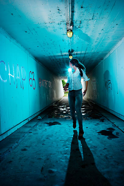 Running girl looking backwards in tunnel