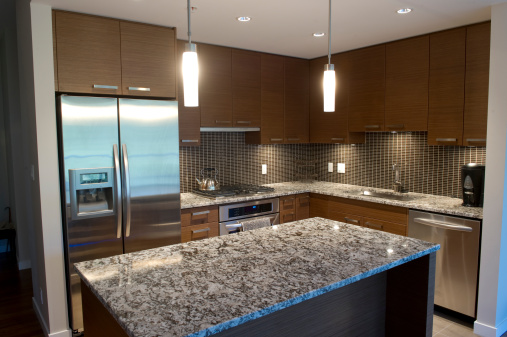 Modern luxury kitchen featuring granite counter tops and stainless steel appliances