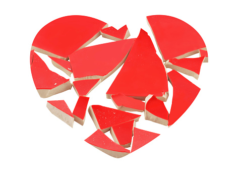 Broken heart concept with broken ceramic shards isolated on white.Clipping path in heart shape and around white spaces between individual pieces.