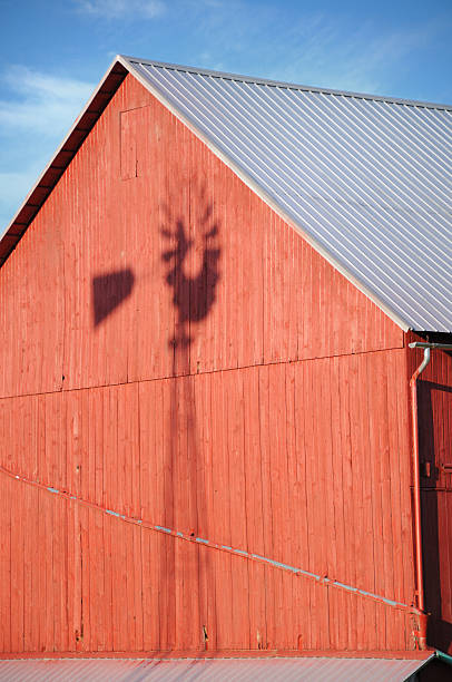 Windmill shadow on side of red barn  red barn house stock pictures, royalty-free photos & images