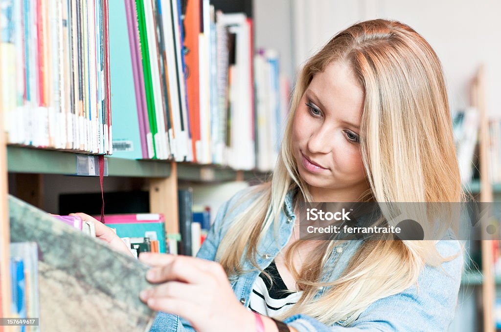 Teenage Student flicking books Happy teenage student flicking books at library or book store Adult Stock Photo