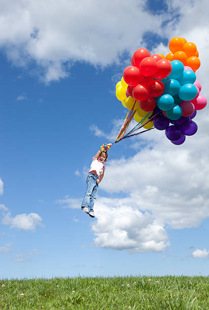 petite fille être époustouflé tout en tenant bouquet de ballons - balloon moving up child flying photos et images de collection