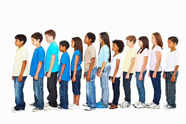 vista laterale di multi etnica bambini in piedi in una riga - persone in fila foto e immagini stock