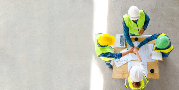 istock Teamwork of civil technician engineer and professional architect stacked hand working together while discuss the planning of building construction progress at site 1576503860