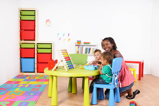 istock African American Woman Kneeling While Interacting With Babies 157650405