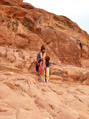 May 2023, Dahab, Egypt: Bedouin woman sitting on the mountain range of Mount Sinai. Religions and Berber culture of the Arabian desert. Egyptian civilization.
