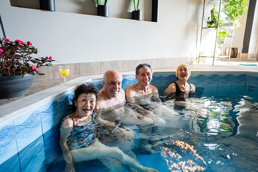 Portrait of senior friends at an indoors resort spa pool