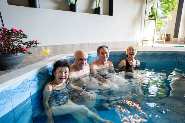 Portrait of senior friends at an indoors resort spa pool Portrait of senior friends at an indoors resort spa pool body positive couple stock pictures, royalty-free photos & images