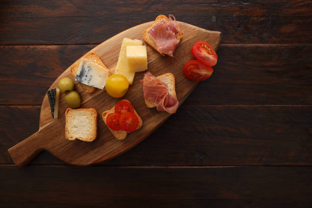 Still life. Sliced tomatoes, cheese sausage salami on a white plate. Light background.