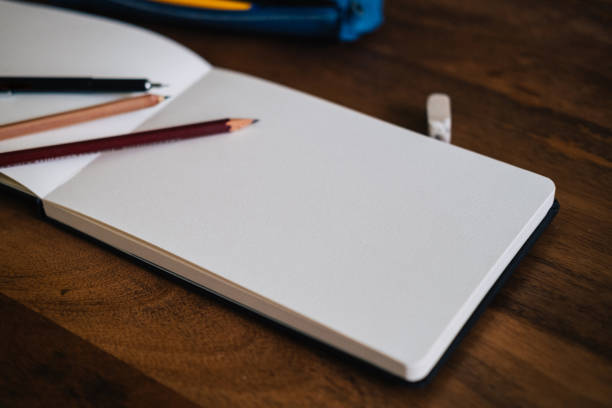 Notebook and pencils on a wooden table, copy space