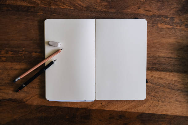 istock Vertical style blank sketchbook on wooden table with crayons 1576544299