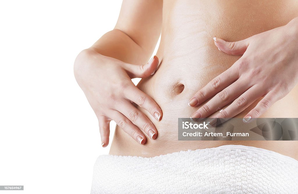 Someone with their hands pressing against their belly Woman apply body cream on abdomen isolated on white background Abdomen Stock Photo