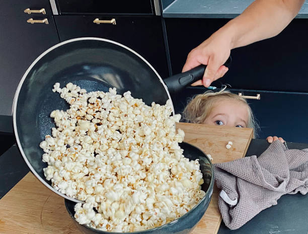 Toddler daughter watching making Popcorn​​​ foto