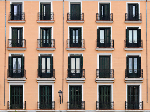Building facade with typical windows and balconies - Madrid, Spain.