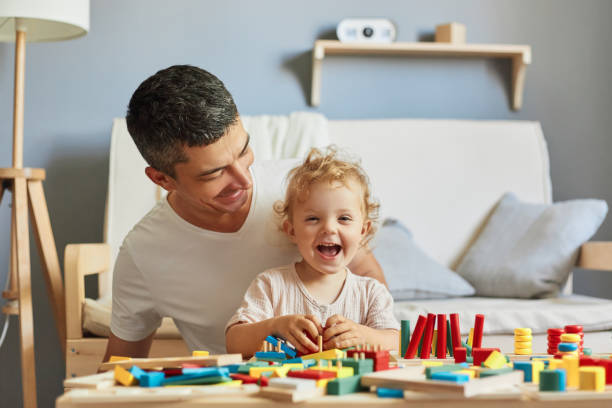 istock Imaginative storytelling games. Cognitive puzzle challenges. Montessori teaching method. Baby girl playing sorter with her father in living-room. 1576626678