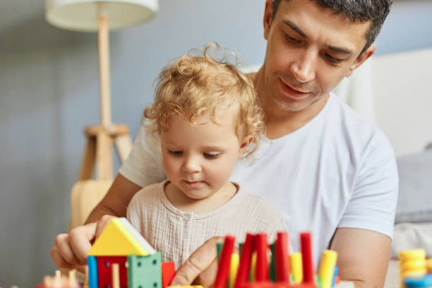 istock Educational playtime fun. Colorful toy collection. Creative art exploration. Parent-child bonding time. Baby girl playing sorter with her father at home. 1576626825