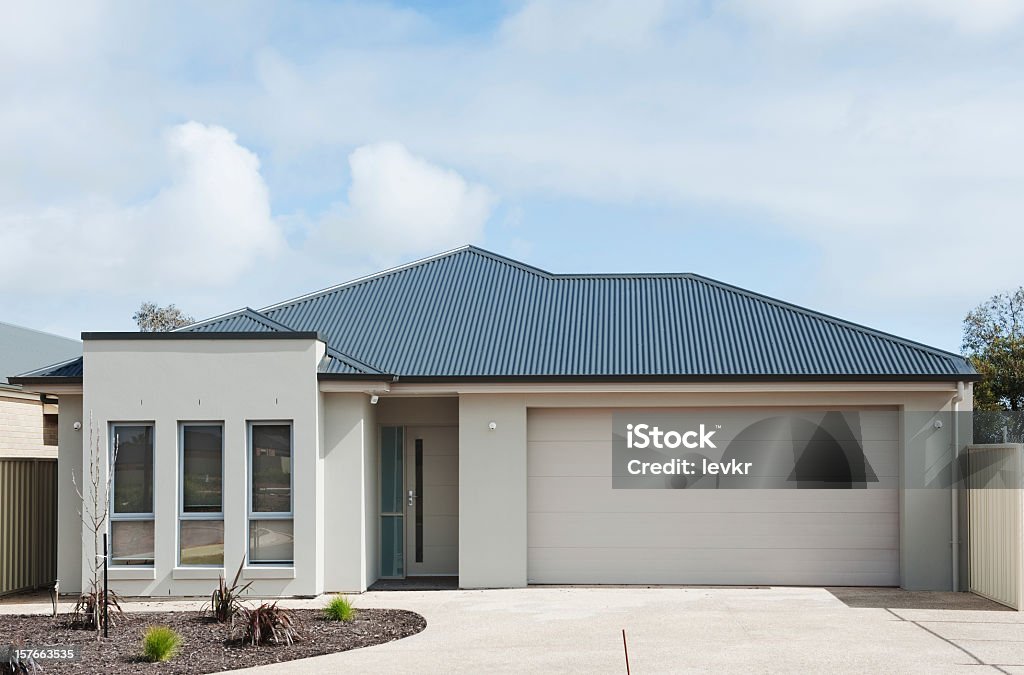 Exterior of a white modern suburban home with blue tile roof typical  facade of a modern suburban  house House Stock Photo