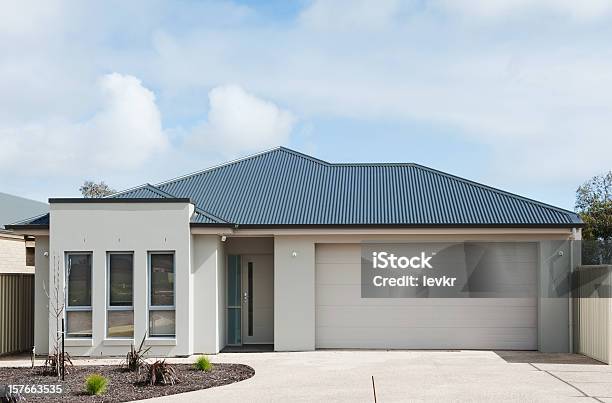 Exterior Of A White Modern Suburban Home With Blue Tile Roof Stock Photo - Download Image Now