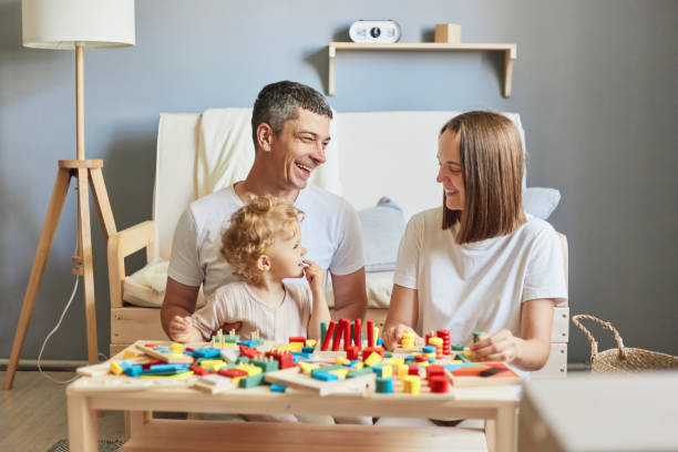istock Interactive learning games. Playful outdoor adventures. Parent-child bonding time. Imaginative storytelling fun. Mother father and her child girl playing with colorful logical sorter toy. 1576637878