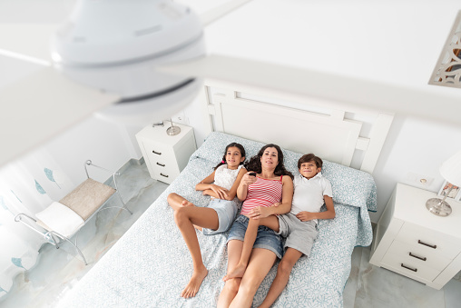 Mother and children at hone conecting ceiling fan