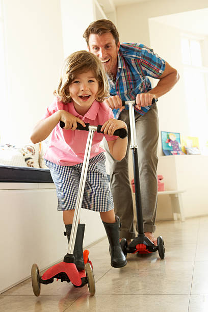 istock Father And Son Riding Scooters Indoors 157668168