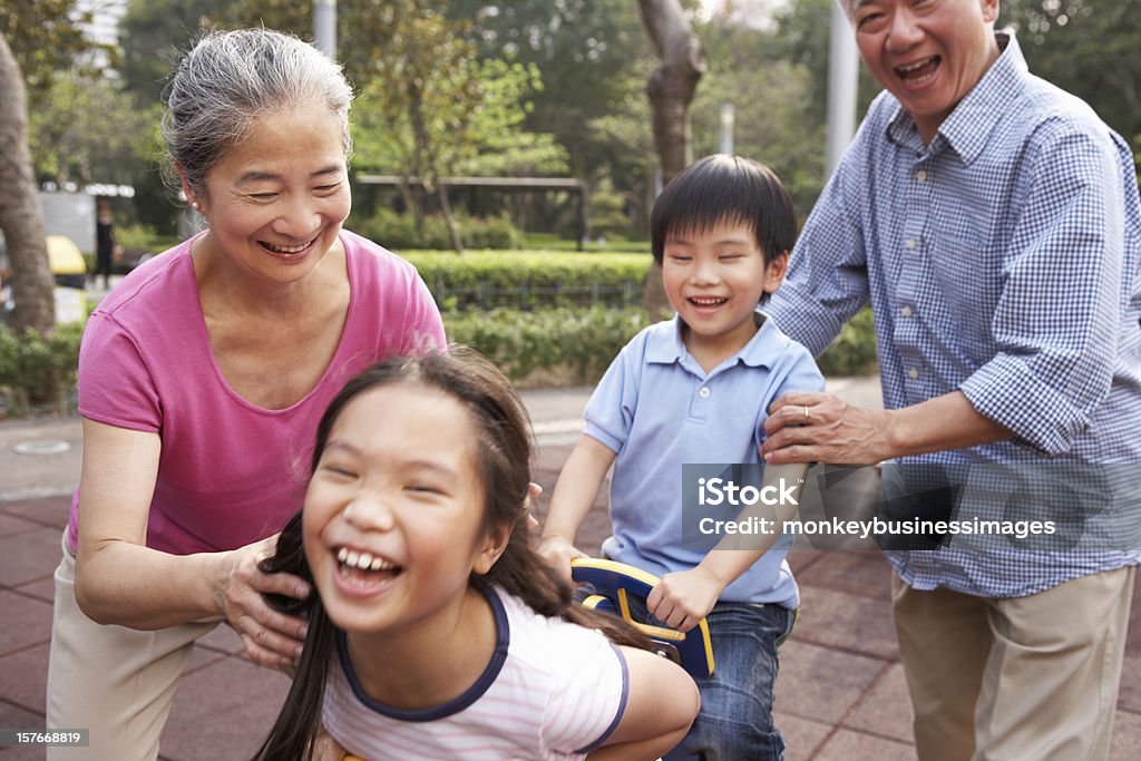 Chinois grands-parents avec petits-enfants jouant au terrain de jeu - Photo de Aire de jeux libre de droits