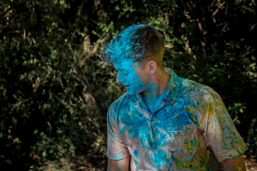 Man sprayed with holi powder yellow and blue