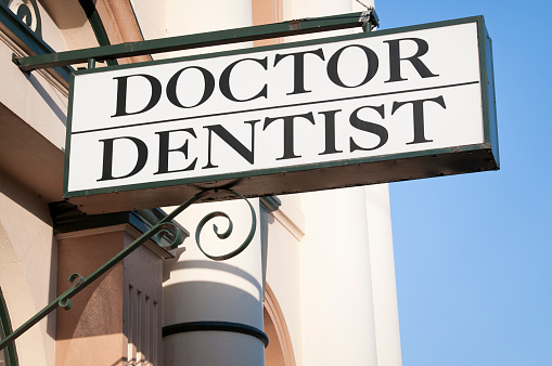 A sign advertising the entrance to a Doctor's and Dentist's surgery.