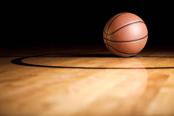 A single basketball sitting on the court stock photo