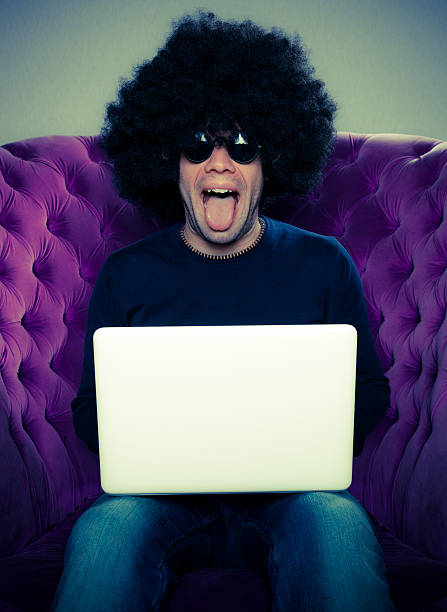 istock Man With an Afro Wig and a White Laptop 157671587