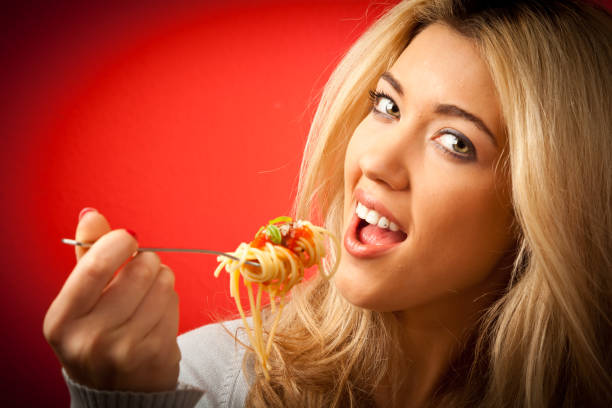 istock young woman having spaghetti 157671597