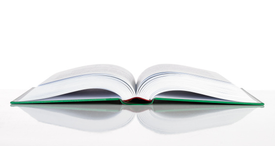 Open book in hardcover on a white background. Copy space.