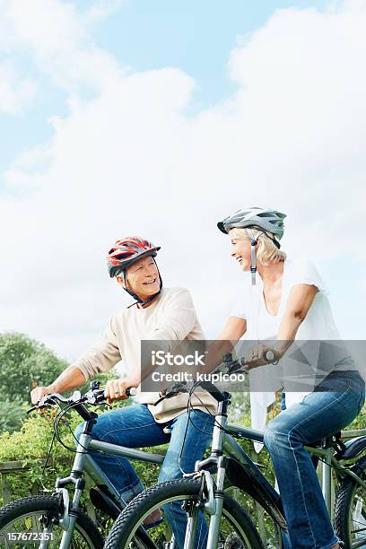 Maduro Feliz Hombre Y Mujer En Ciclo Paseo En Campo Foto de stock y más banco de imágenes de Andar en bicicleta