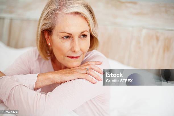 Zrelaksowany Dojrzała Kobieta W Łóżku Patrząc Od Hotelu - zdjęcia stockowe i więcej obrazów Kobiety