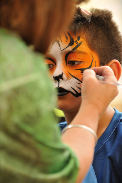 rapaz com uma máscara de tigre pintado na sua hace - face paint human face mask carnival imagens e fotografias de stock