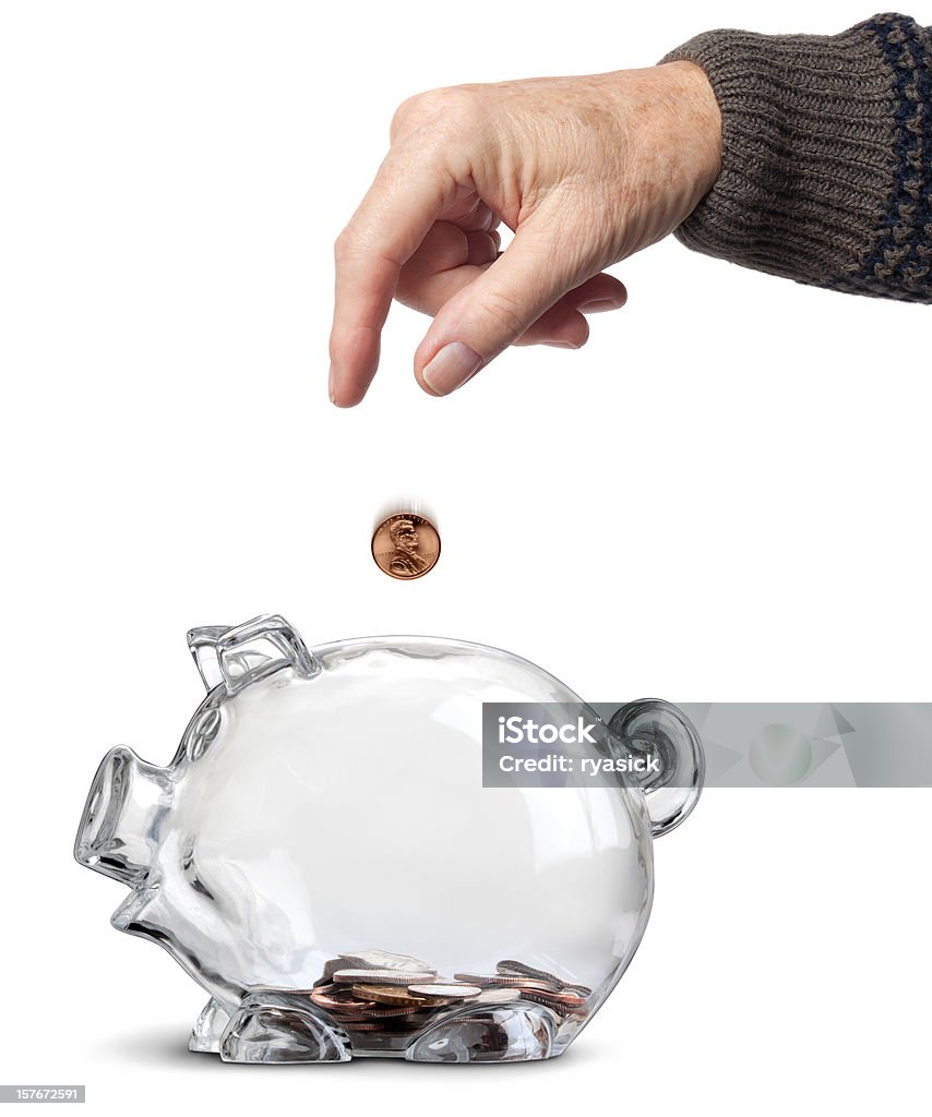 Elderly Hand Dropping Coins Into Almost Empty Piggy Bank Isolated  Coin Stock Photo