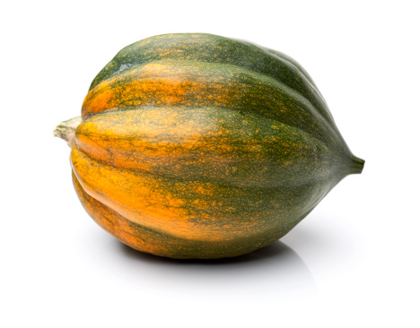 A homegrown acorn squash on a white background.