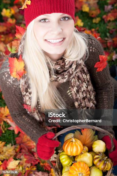 Mujer Sonriente Sostiene Cesta De Pumpkins Foto de stock y más banco de imágenes de Alegría - Alegría, Calabaza gigante, Mujeres