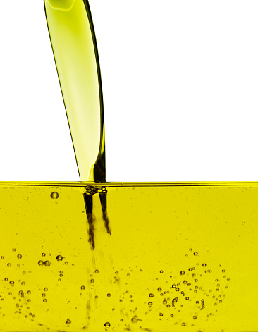 olive oil being poured into glass container, please note that the many small bubbles may resemble sensorspots.