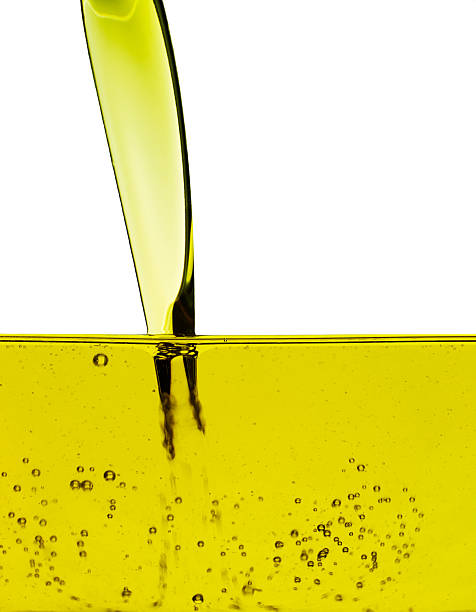 Yellow oil being poured into a container stock photo