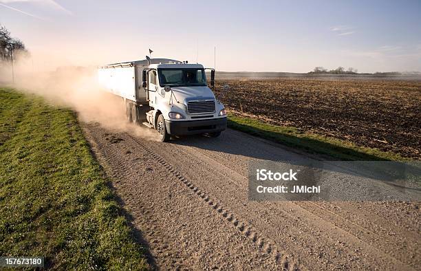 Carro De Grano Hauling En Polvorientas Camino Rural Región Central De Los Estados Unidos Foto de stock y más banco de imágenes de Grano - Planta