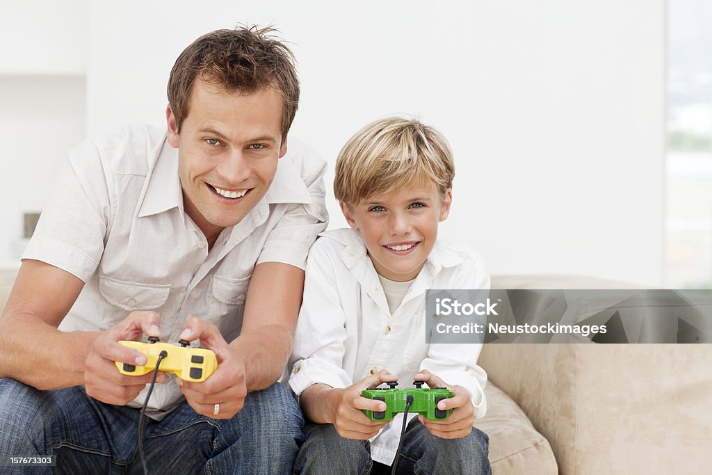 Uśmiechająca się Ojciec i syn, grając w gry wideo - Zbiór zdjęć royalty-free (Gra wideo)
