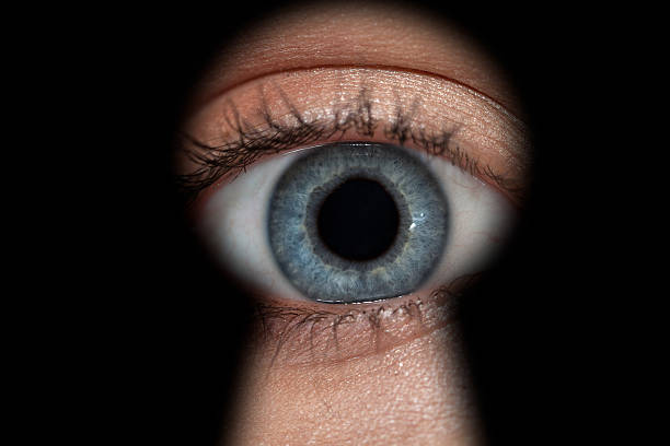 istock Woman's eye in keyhole 157673306